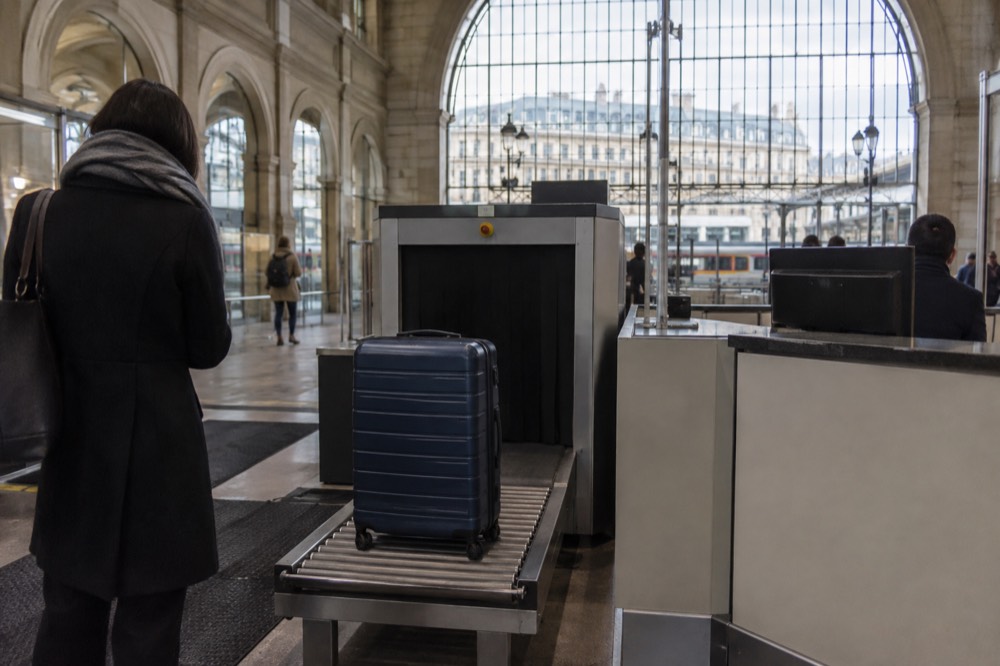 Une valise à côté d'un équipement de contrôle de sécurité à un comptoir de service d'aéroport près de Paris