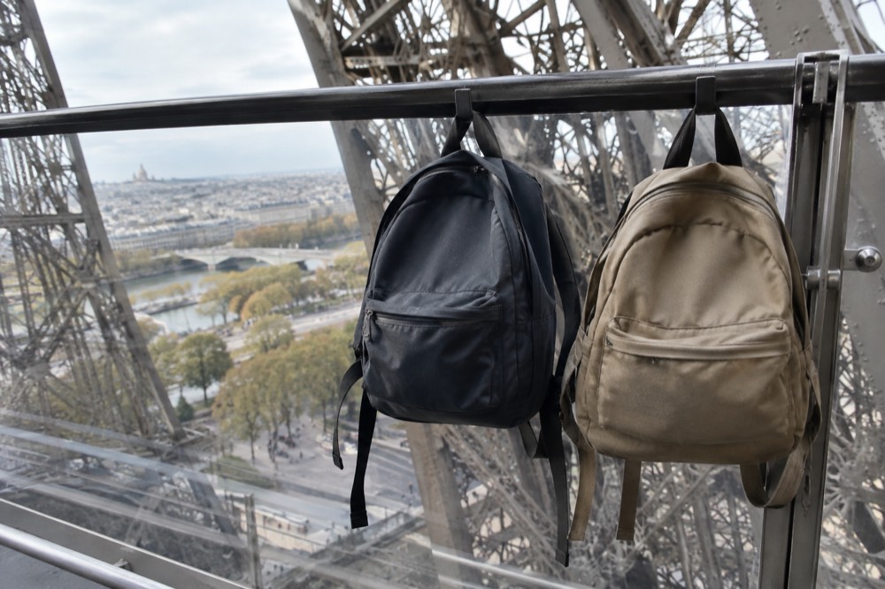 Visitors holding small backpacks on the Eiffel Tower observation deck