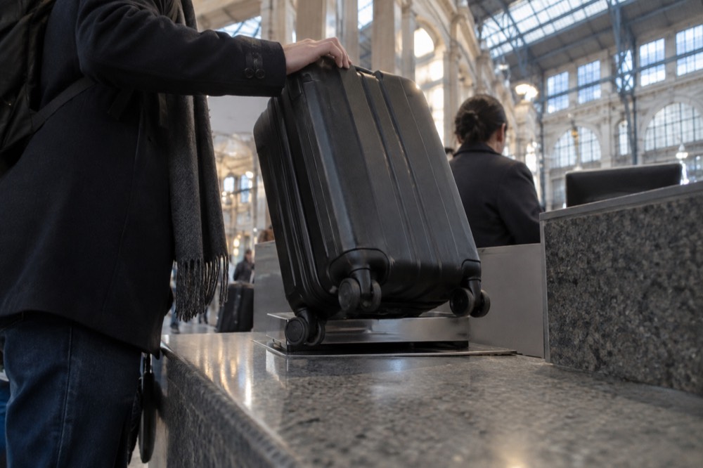 Un comptoir de consigne à bagages dans un terminal d'aéroport avec une valise en cours de remise