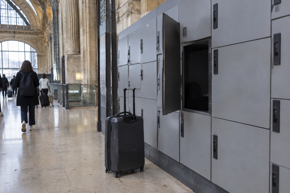 Rangées de casiers à bagages en libre-service gris le long du mur d'un couloir de gare