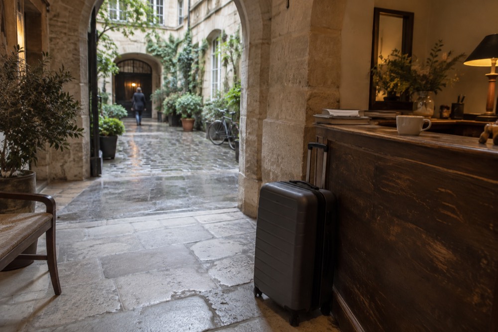 Valise posée près de la réception d'un hôtel dans un hall parisien