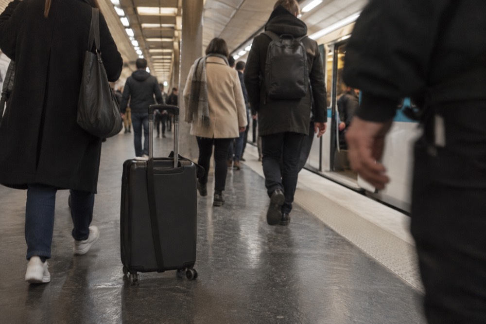 Un quai de métro bondé à Paris avec une valise posée parmi les voyageurs