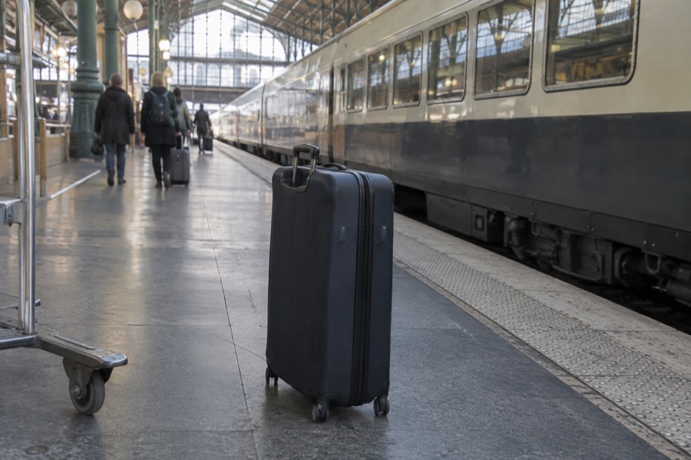 Train Eurostar jaune à quai en gare du Nord, à côté d'une valise fermée
