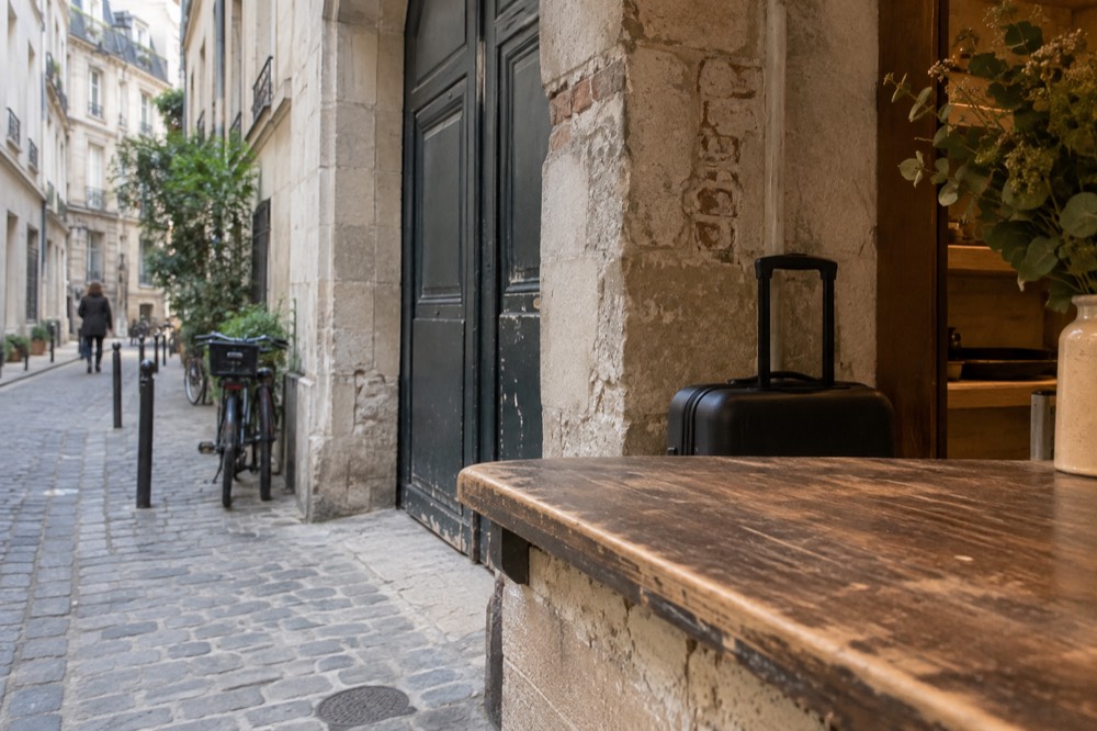 Un petit comptoir de boutique à Paris avec une valise posée derrière