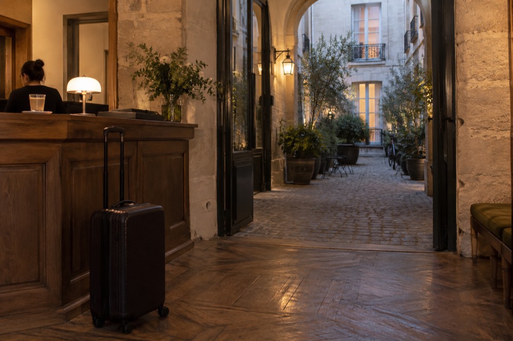 Une valise qui attend à côté du comptoir de réception d'un hôtel dans un hall parisien