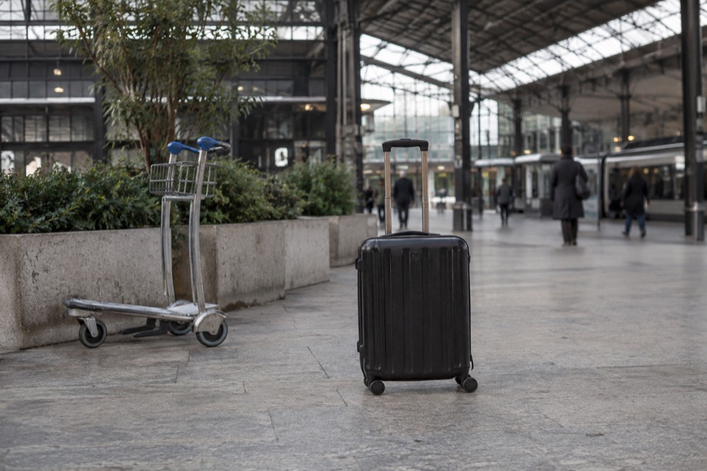 Une valise qui attend au milieu du vaste hall d'une gare parisienne