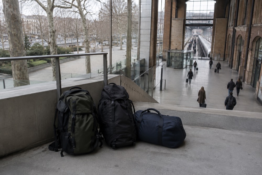 Hall de gare moderne en verre avec des voyageurs qui marchent et aucun casier visible