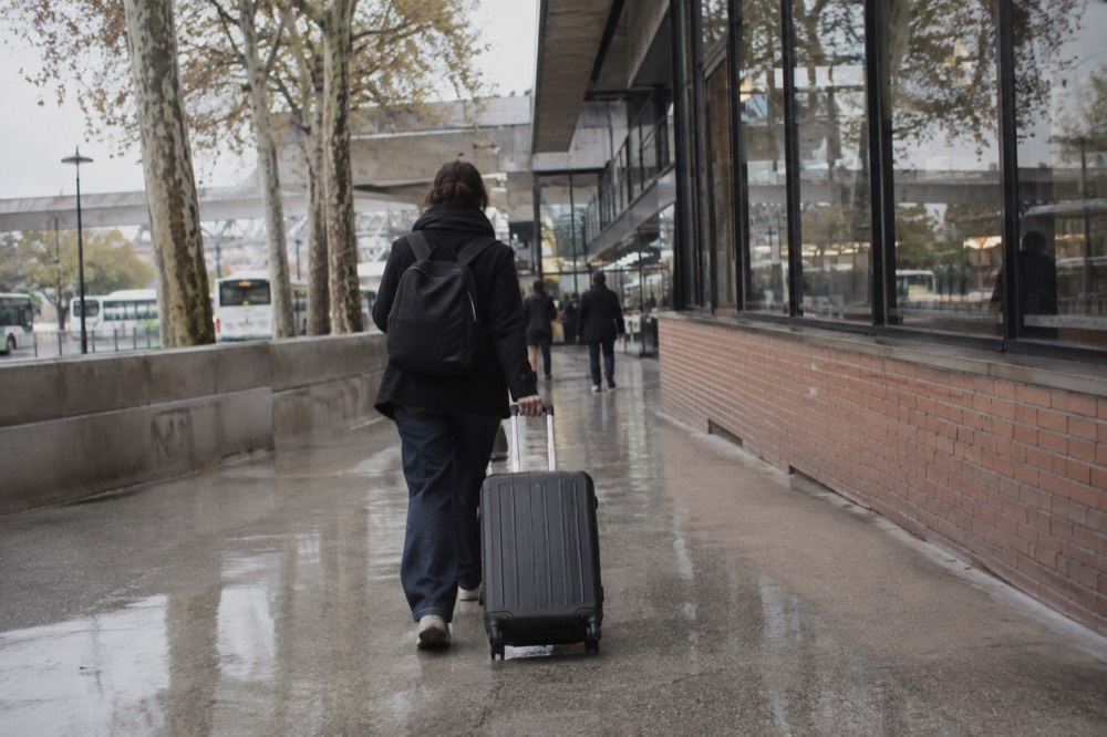 Un voyageur tirant une valise dans un couloir d'aéroport près de Paris