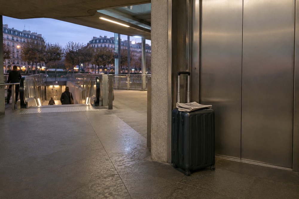 Une valise à côté des portes de l'ascenseur sur un quai de métro parisien moderne