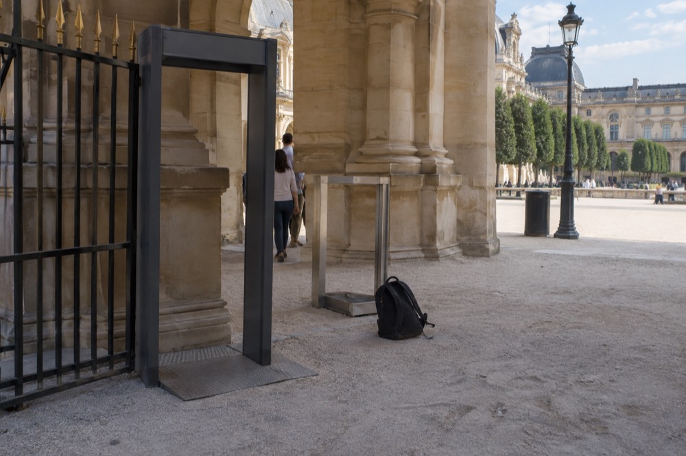 A security gate and bag gauge at the entrance of a Paris monument