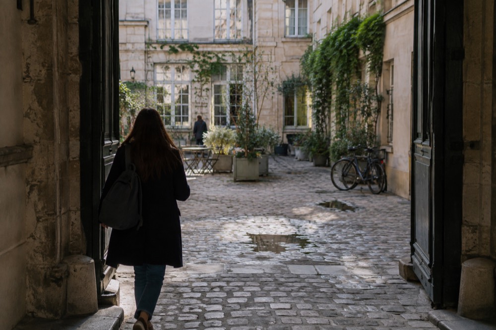 Un petit sac à dos porté à travers la grille dorée ornée de Versailles dans la lumière du matin