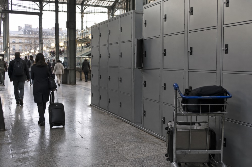 Rangée de casiers libre-service gris le long du mur d'un couloir de gare
