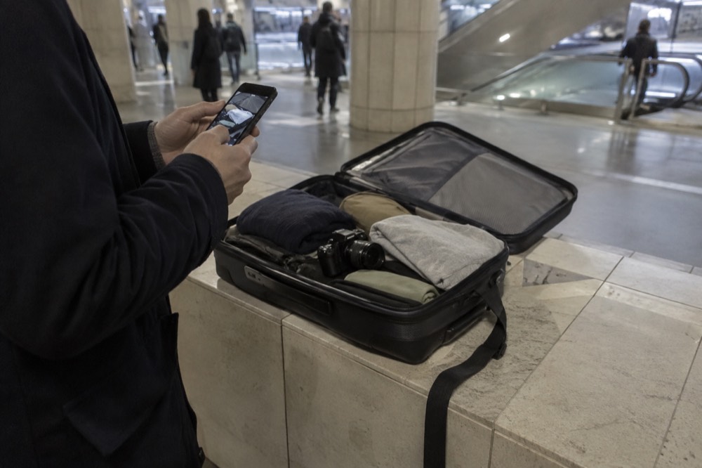 Une valise ouverte photographiée avec un téléphone avant l'arrivée.